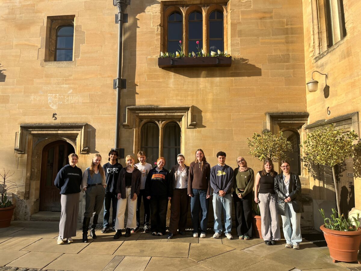 Large group of people, the Telethon 2025 team, standing outdoors in front of a college building