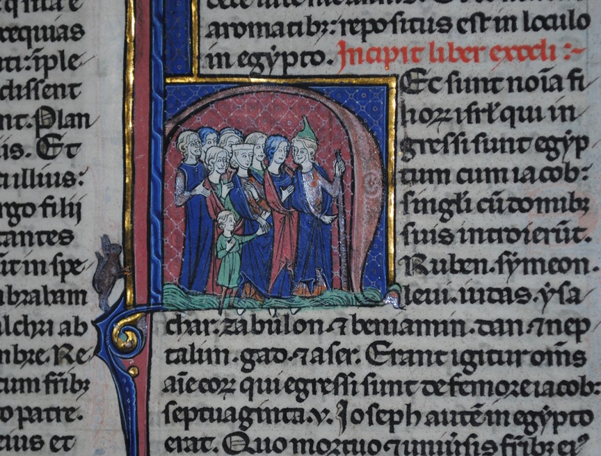Open illuminated medieval manuscript showing Latin text in two columns with decorative initials and a small painted miniature