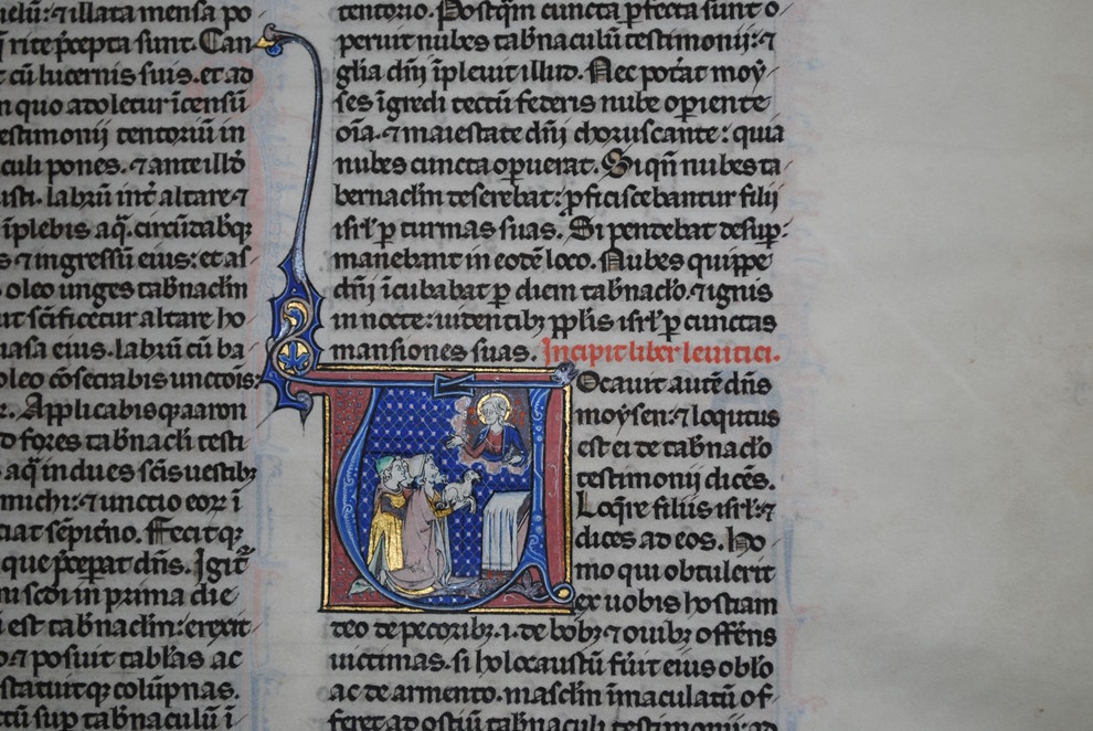 Illuminated medieval manuscript page with Latin text and a colourful miniature depicting a religious scene in blue and gold tones