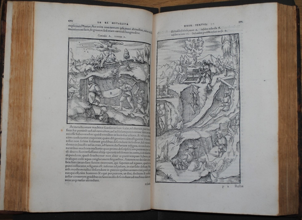 Open Renaissance scientific book showing woodcut illustrations of miners working underground with Latin text on both pages