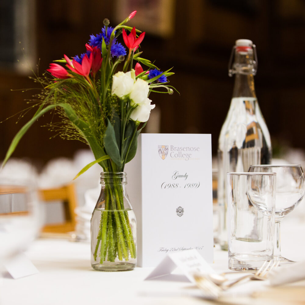 Floral arrangement and place setting on a dining table for the Gaudy 1988 and 1989