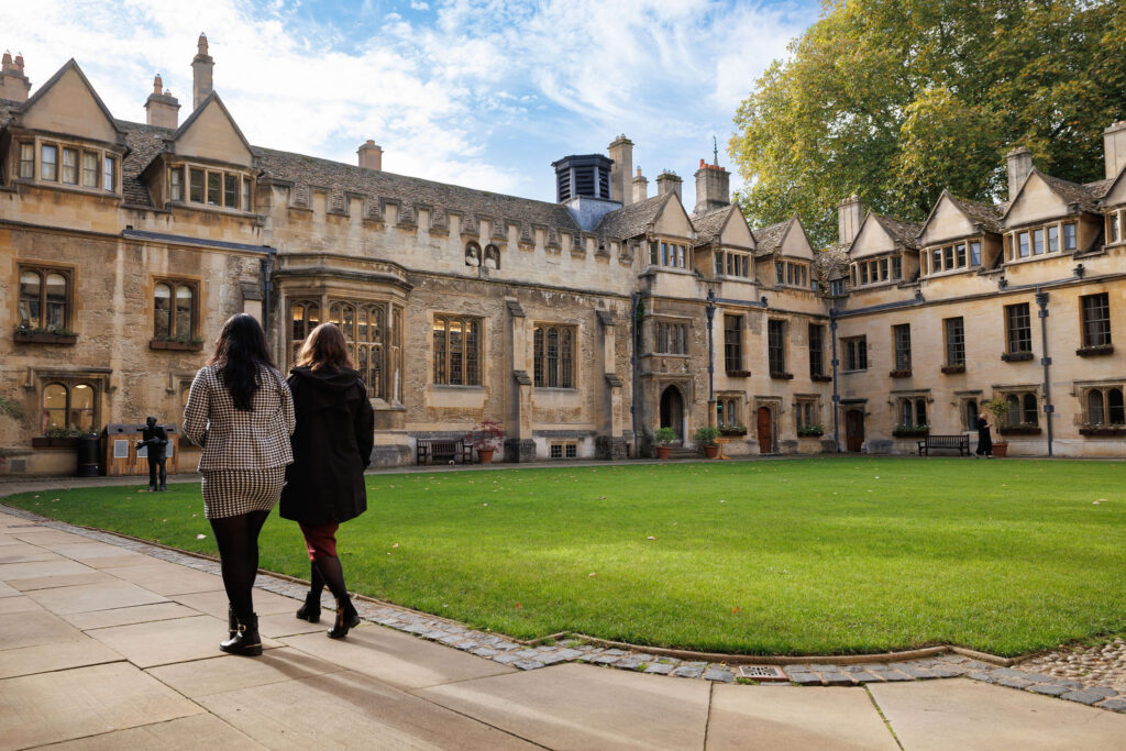 Two people walking across the Brasenose College main quad