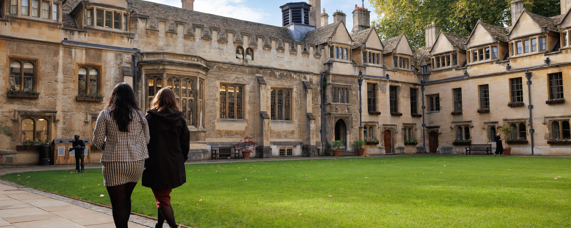 Two people walking across the Brasenose College main quad
