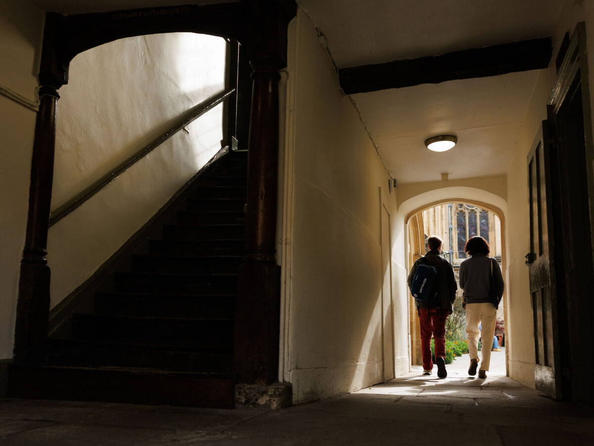 View down a covered college passageway with people walking away