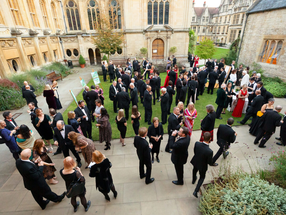 Large group of people gathered outdoors in the quad during an event