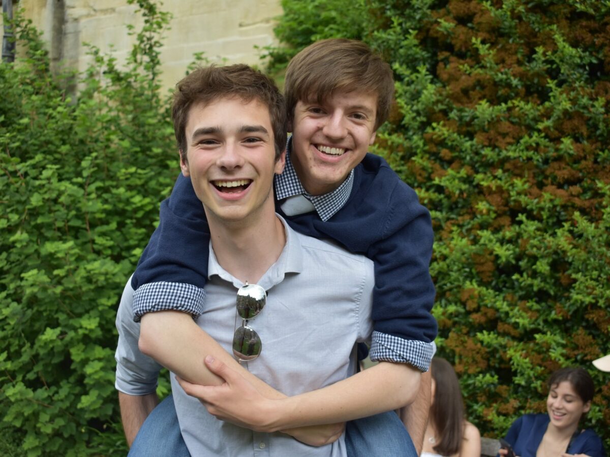 Two people outdoors, one giving the other a piggyback