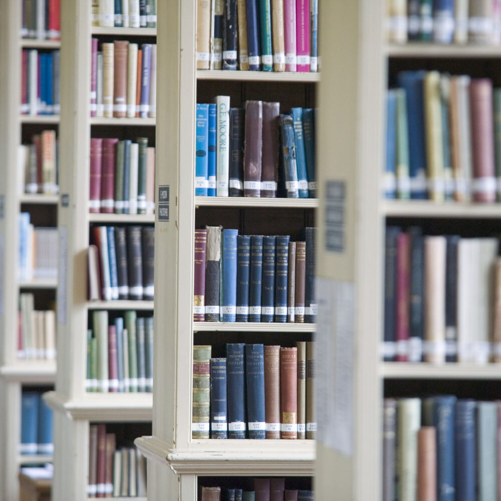 Tall bookshelves filled with books in a college library