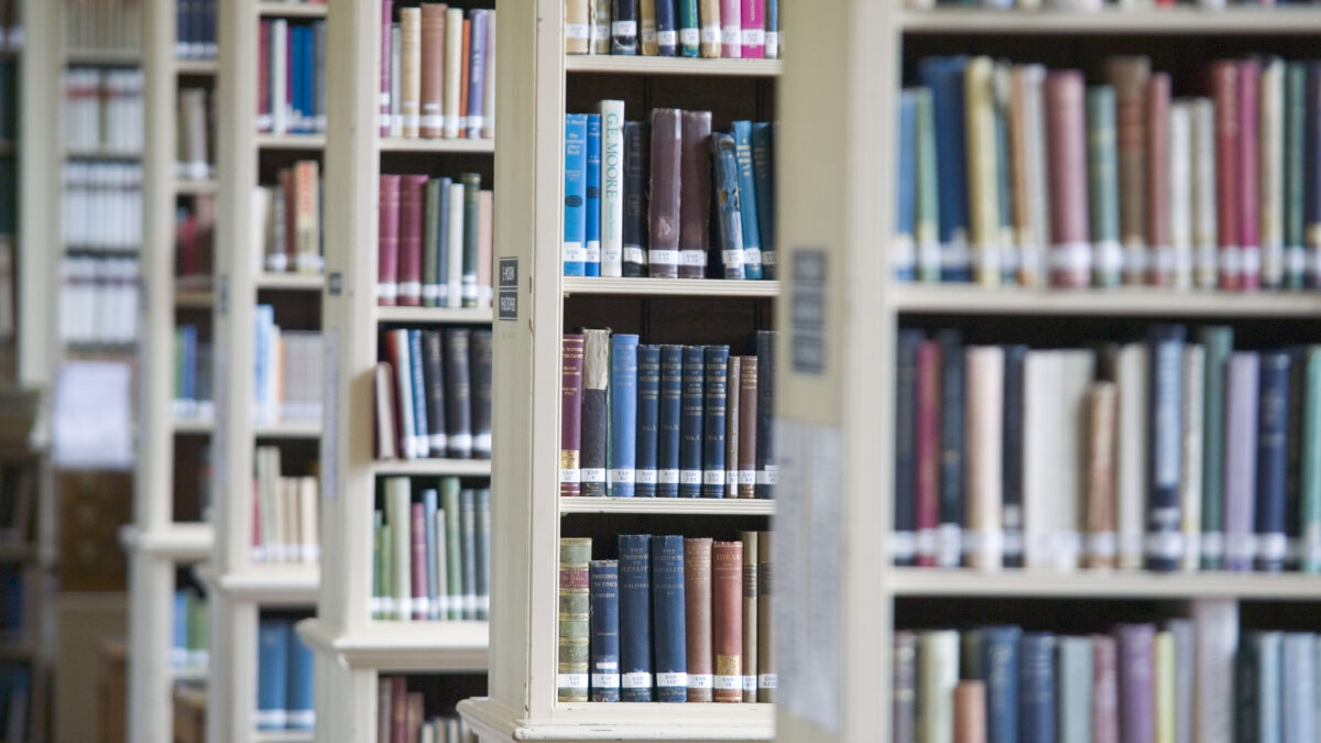 Tall bookshelves filled with books in a college library