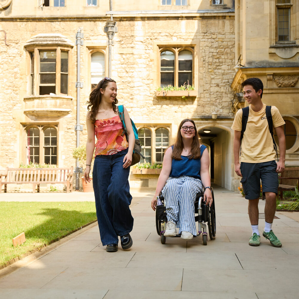 Three students in the quad in front of a doorway