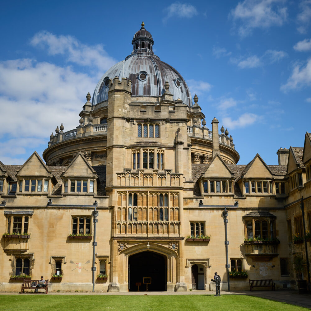 Brasenose College Old Quad in the sunshine against a blue sky with the Radcliffe Camera in the background