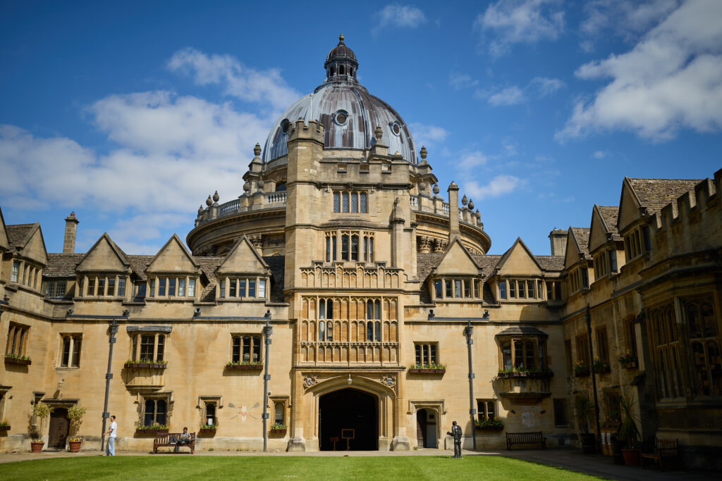 Brasenose College Old Quad in the sunshine against a blue sky with the Radcliffe Camera in the background