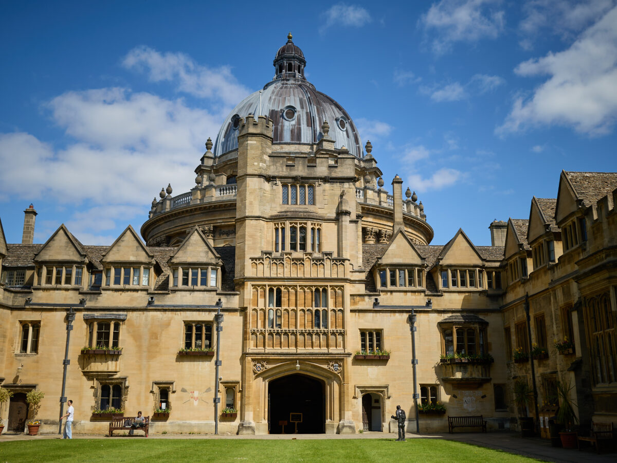 Brasenose College Old Quad in the sunshine against a blue sky with the Radcliffe Camera in the background