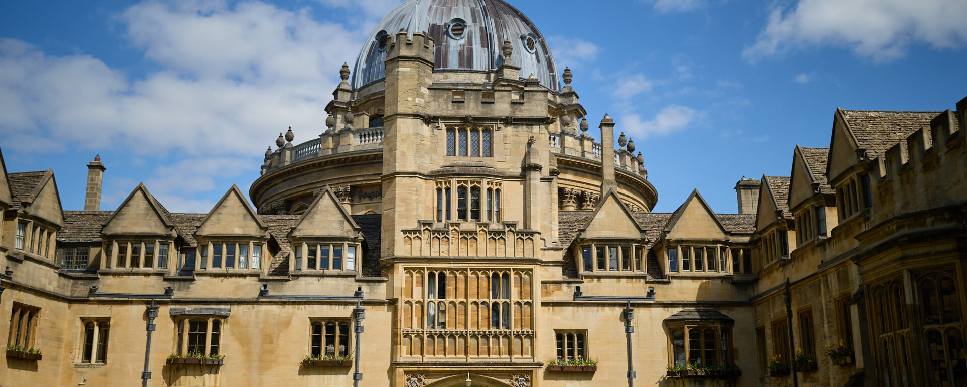 Brasenose College Old Quad in the sunshine against a blue sky with the Radcliffe Camera in the background