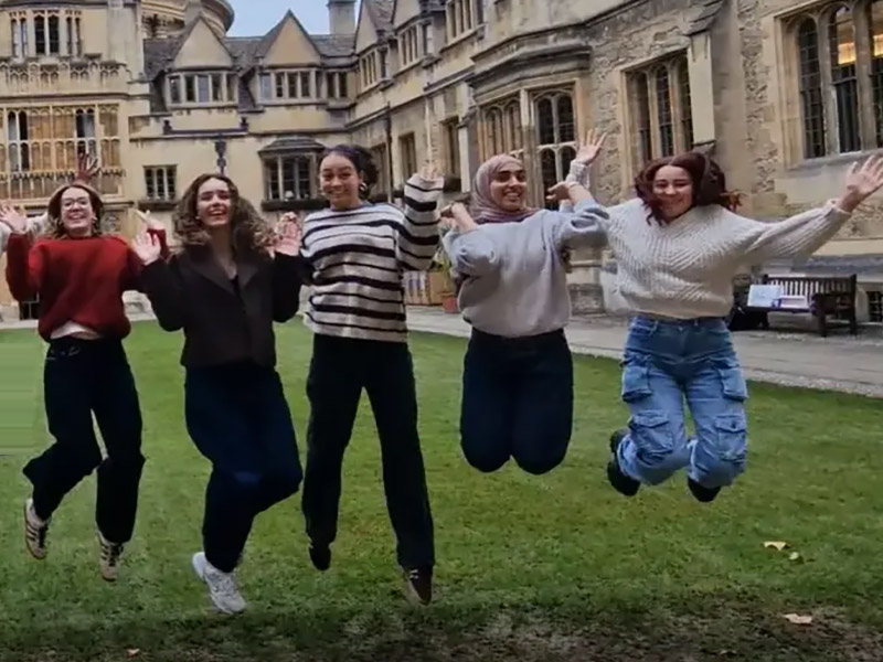 Five students jumping in the air