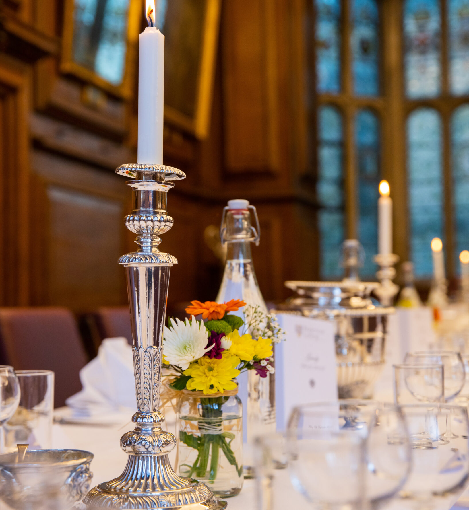 Table set for a formal meal, with glassware and candles arranged neatly