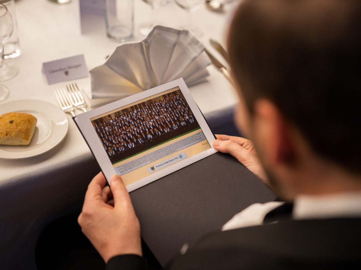 Person looking at an alumni photograph in a formal indoor space