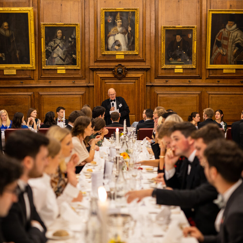 Formal dinner in the college dining hall, with guests seated at long tables
