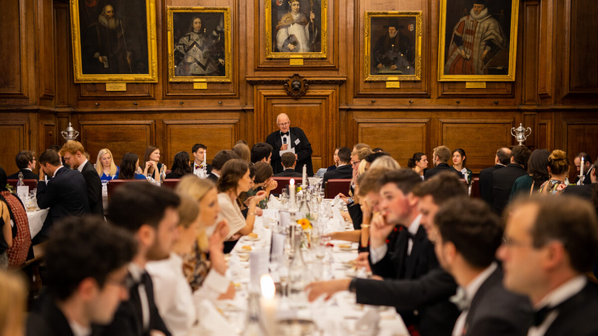 Formal dinner in the college dining hall, with guests seated at long tables
