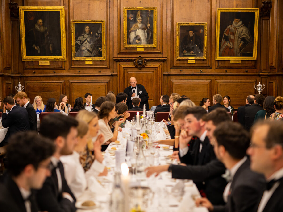 Formal dinner in the college dining hall, with guests seated at long tables