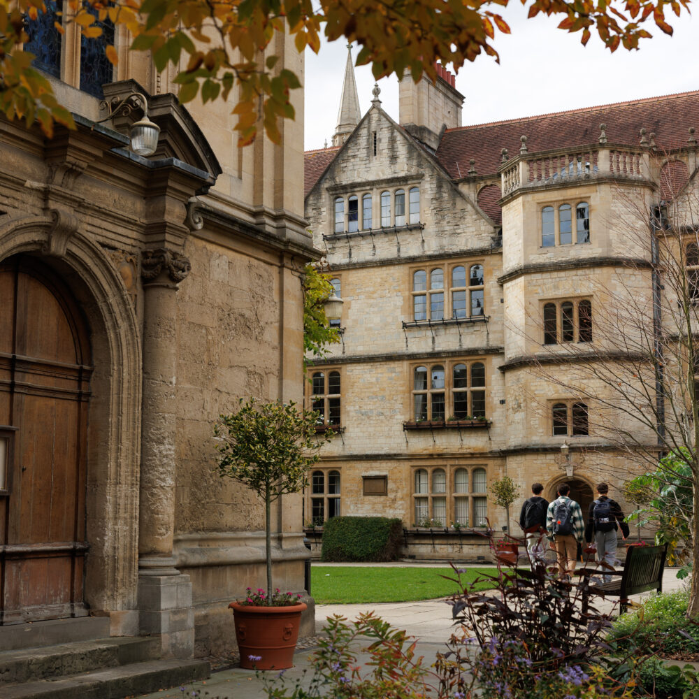 Three students walking across the quad at Brasenose College