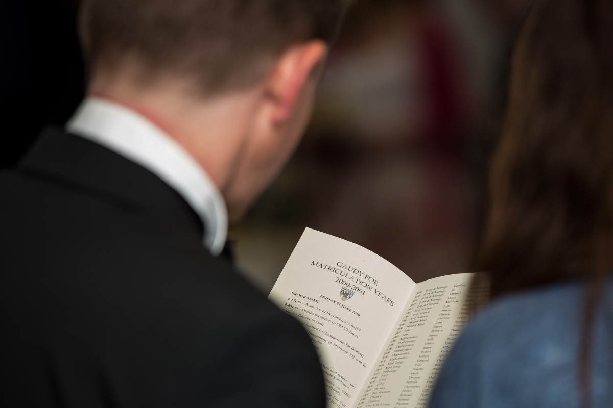 Person holding a Gaudy 2000-2001 booklet open, viewed from behind