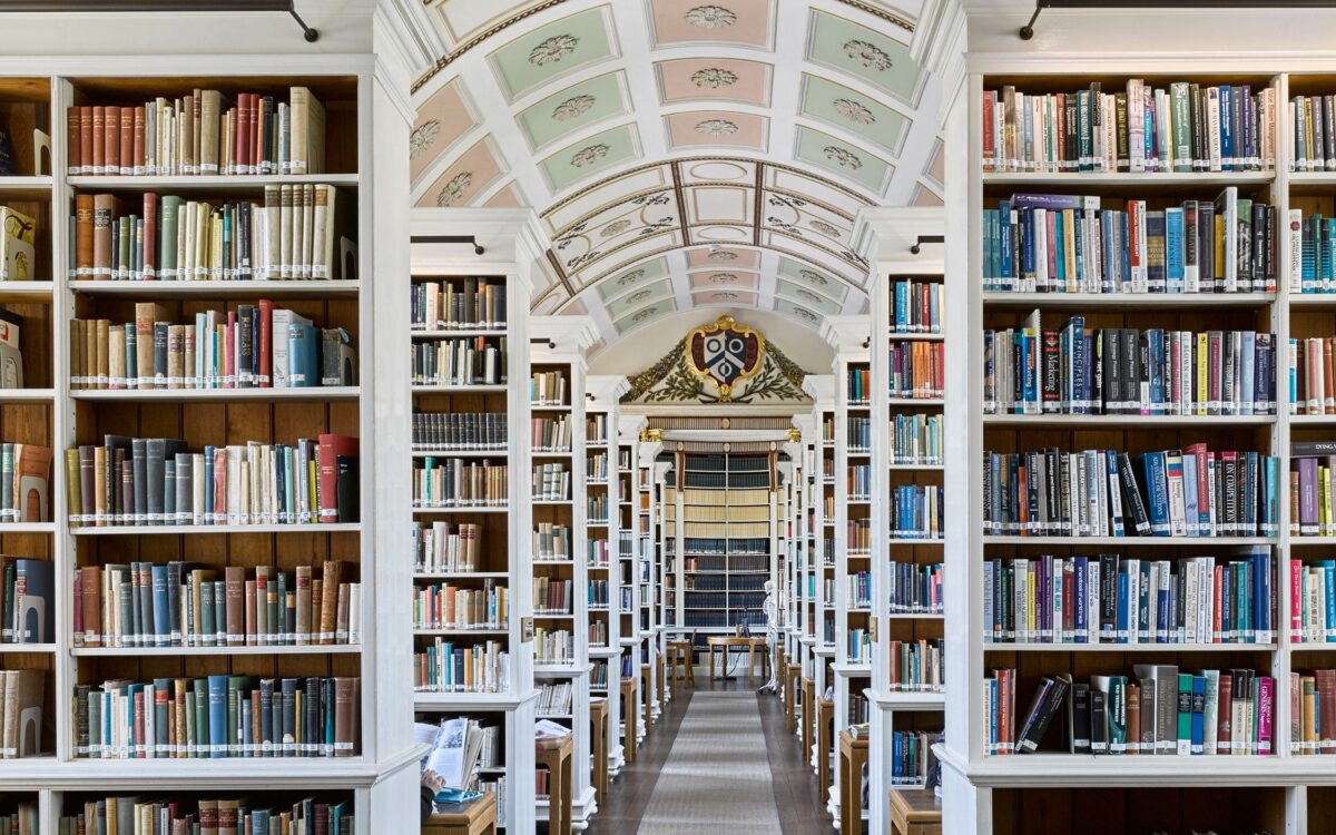 The Main Library with tall bookshelves lining a library aisle beneath an arched ceiling