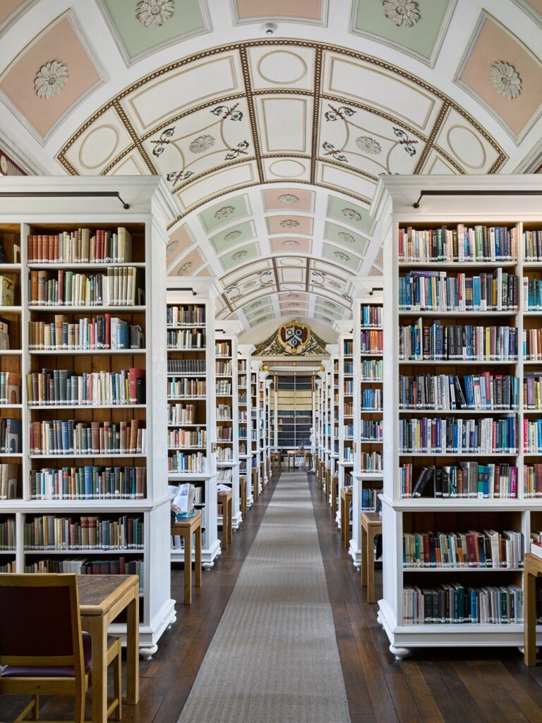 The Main Library with tall bookshelves lining a library aisle beneath an arched ceiling