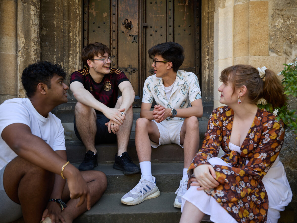Small group of students sitting together outdoors on stone steps