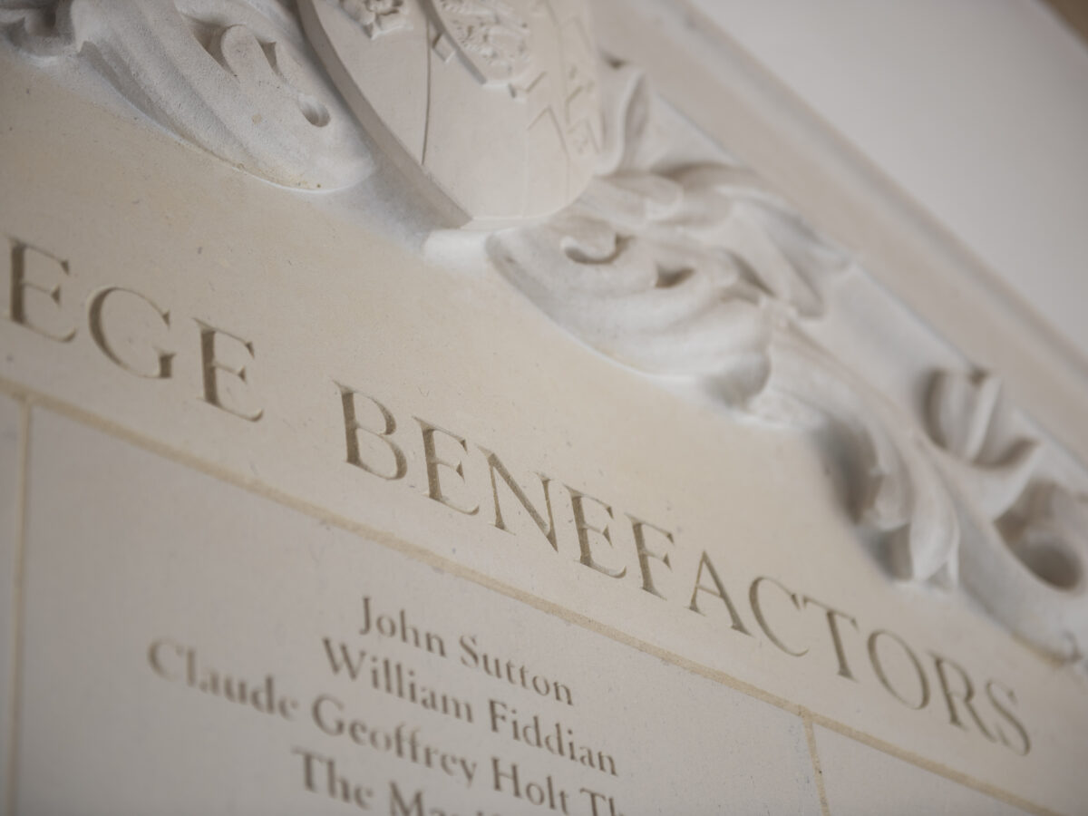 Close-up of a stone benefactors plaque on building wall