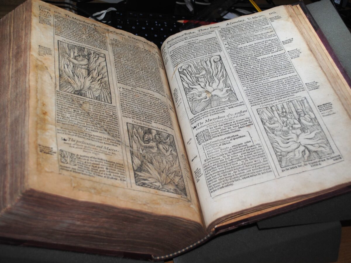 Woodcuts from an open book showing martyrs burning at the stake