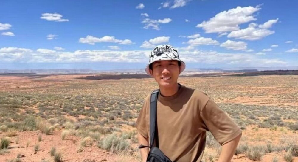 Person standing outdoors in an open wide and dry landscape under a blue sky