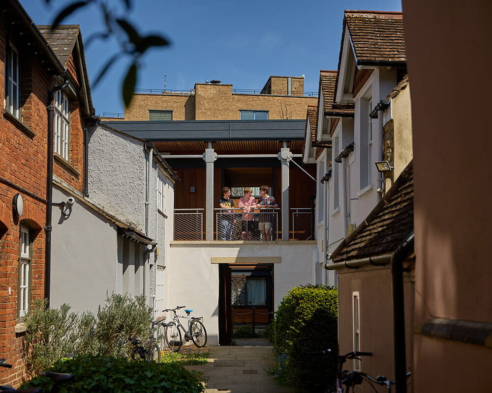 Students standing on a balcony overlooking a Brasenose College accommodation courtyard