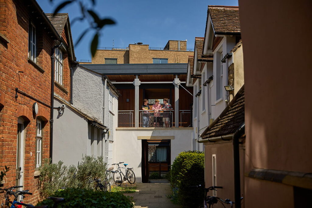 Students standing on a balcony overlooking a Brasenose College accommodation courtyard
