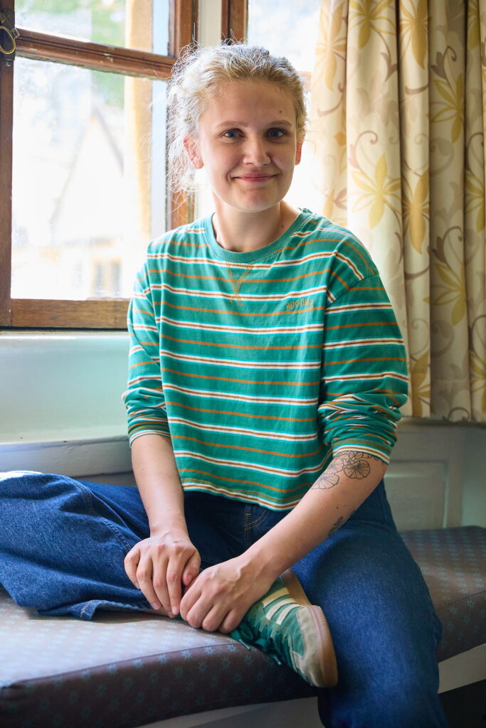 Student sitting by a window in a college room
