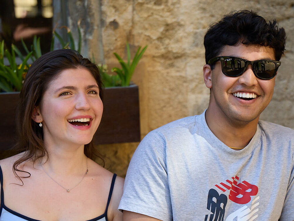 Two students sitting together on a bench in the quad