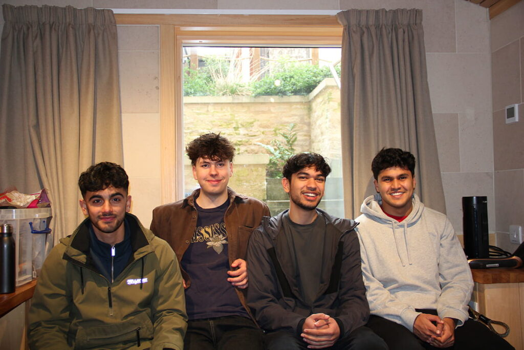 Four students sitting together in accommodation