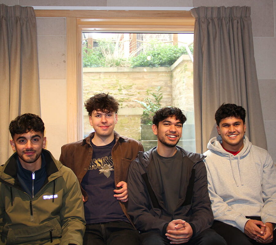 Four students sitting together in accommodation