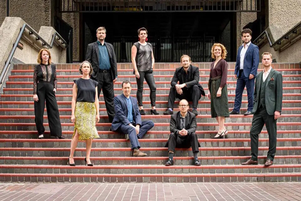 Group portrait of the vocal ensemble EXAUDI on outdoor steps