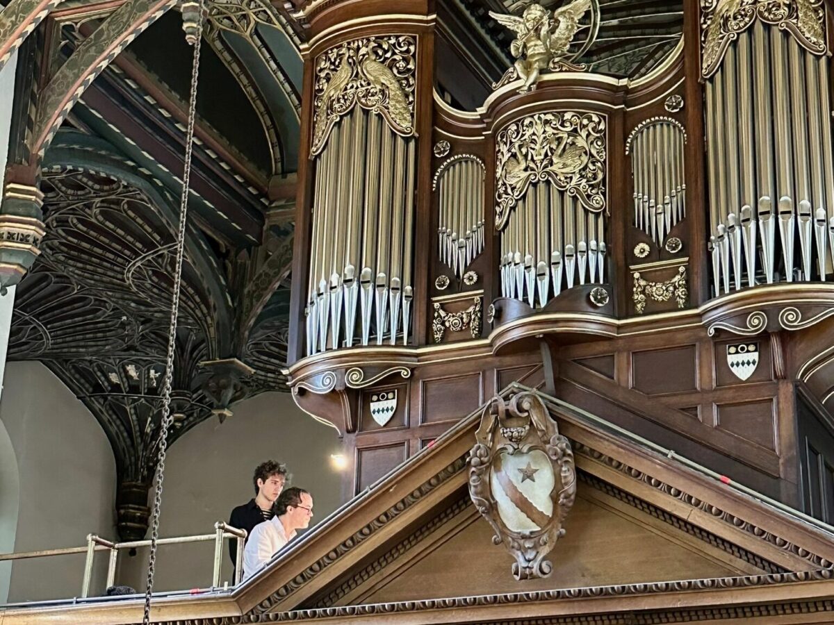The chapel organ and vaulted ceiling, with two people visible in the organ gallery.