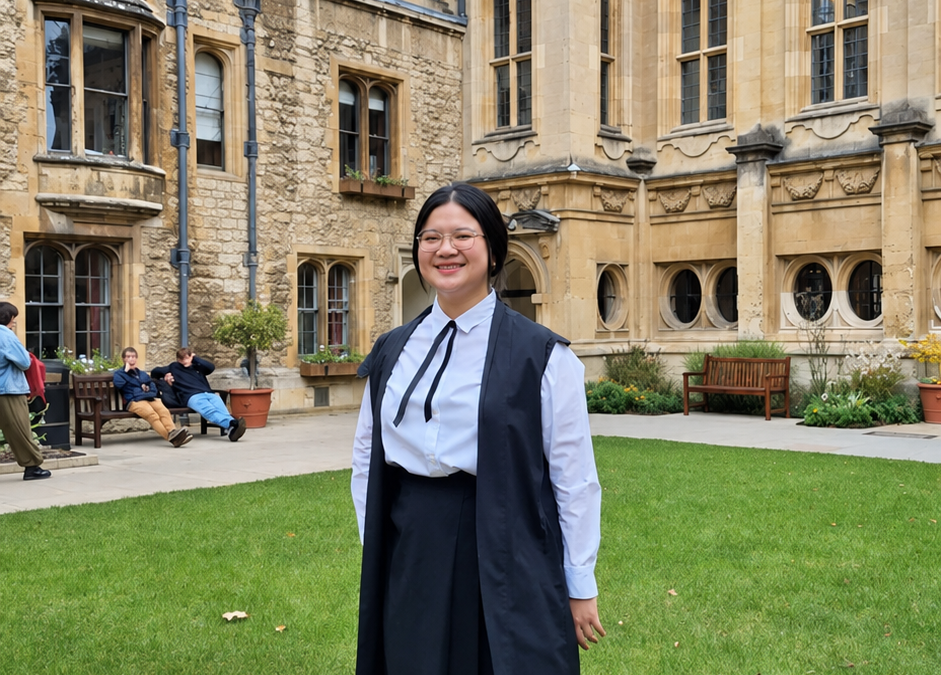 Scholarship student Belinda standing in Deer Park in her gown, with a view behind of the library and the Radcliffe Camera.