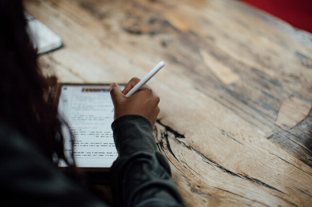 Student writing on a tablet