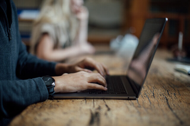 Man with hands on keyboard of a laptop