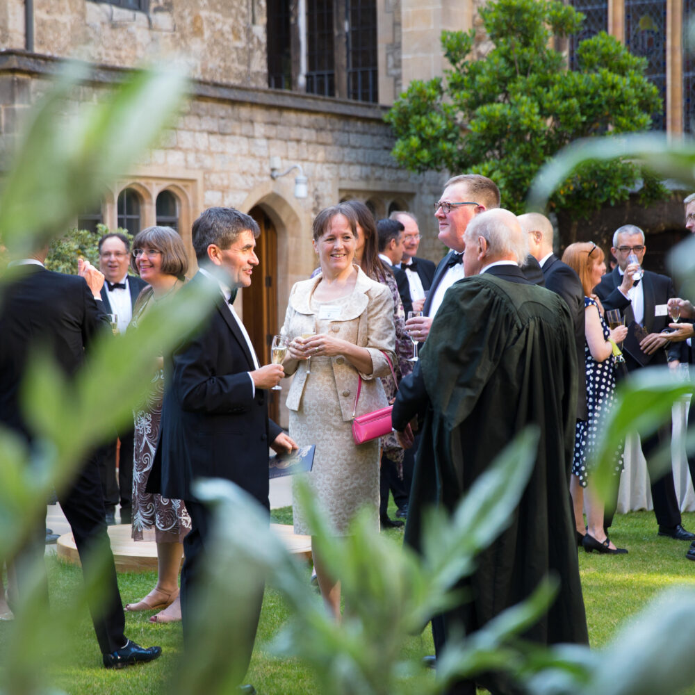 Group of alumni in black tie at a drinks reception in Deer Park