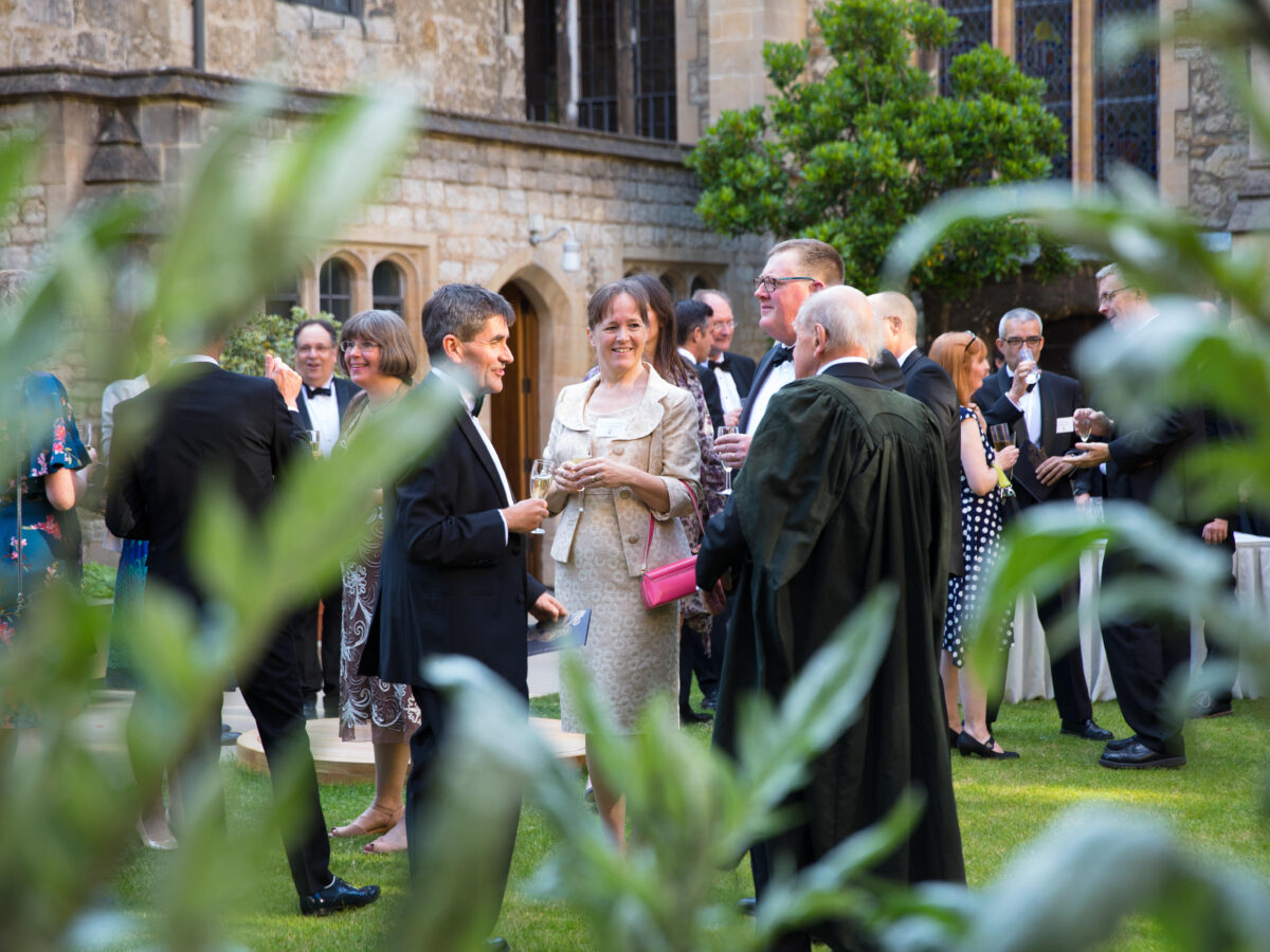 Group of alumni in black tie at a drinks reception in Deer Park
